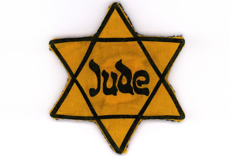 a yellow star of david badge bearing the german word "jude"