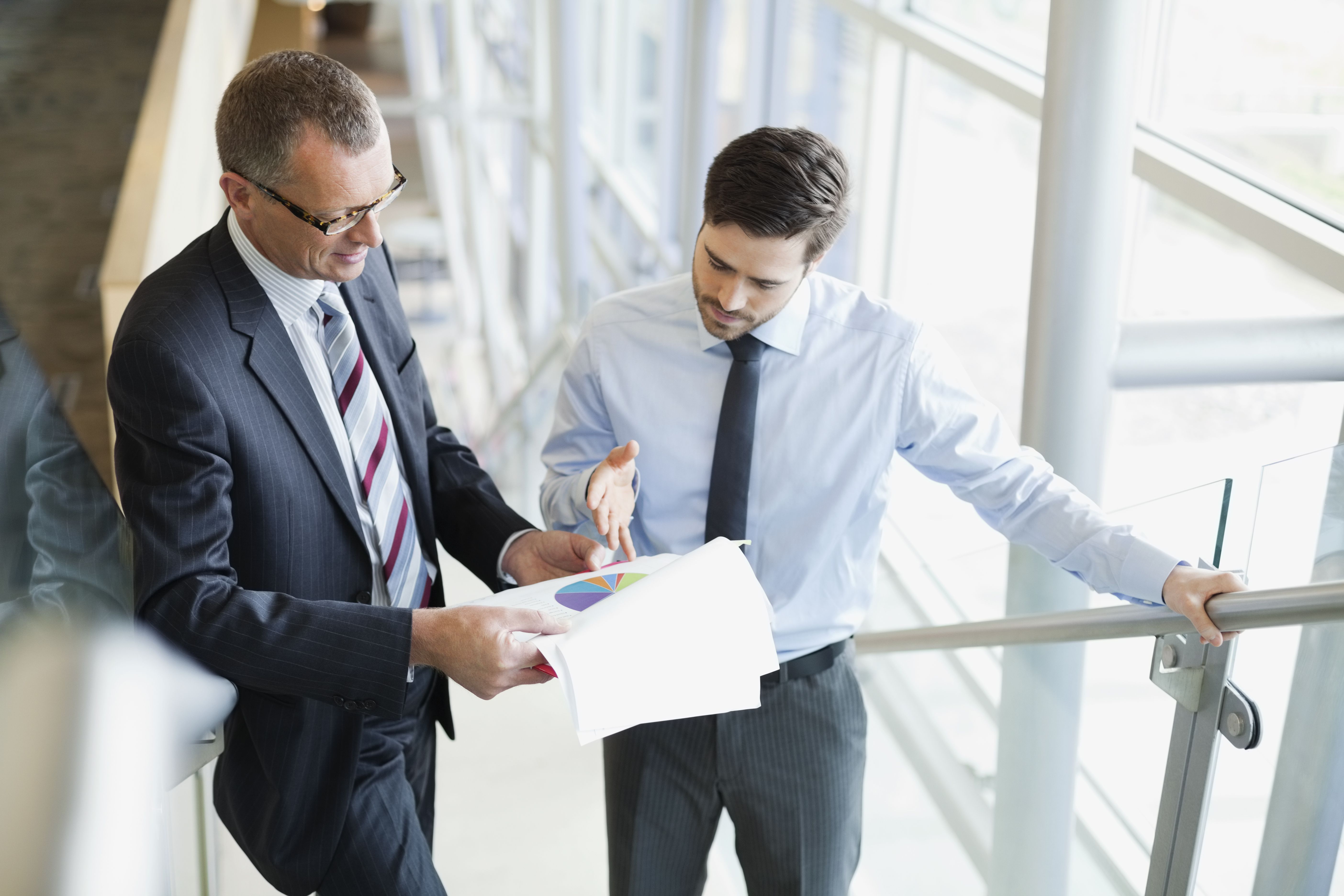 businessmen-discussing-pie-chart-180408552-599f657fd963ac0011347fec.jpg