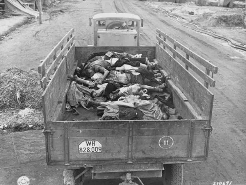 A picture of a British Army truck transporting corpses to mass graves for burial.