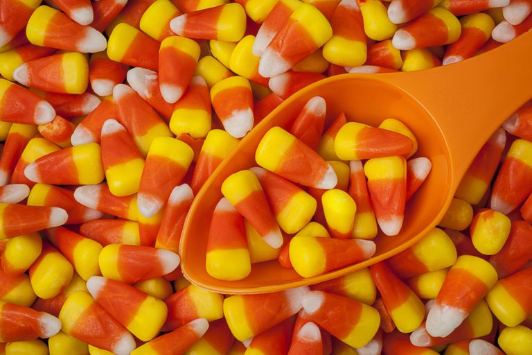 A pile of candy corn with a spoon.