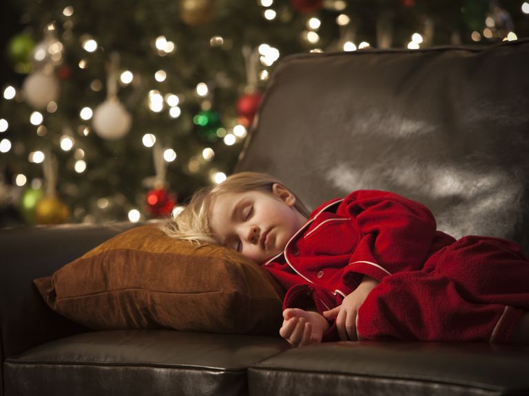 child sleeping on sofa at Christmas - holiday stress in children