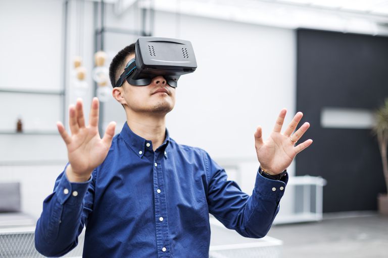 young asian man with VR in modern cafe