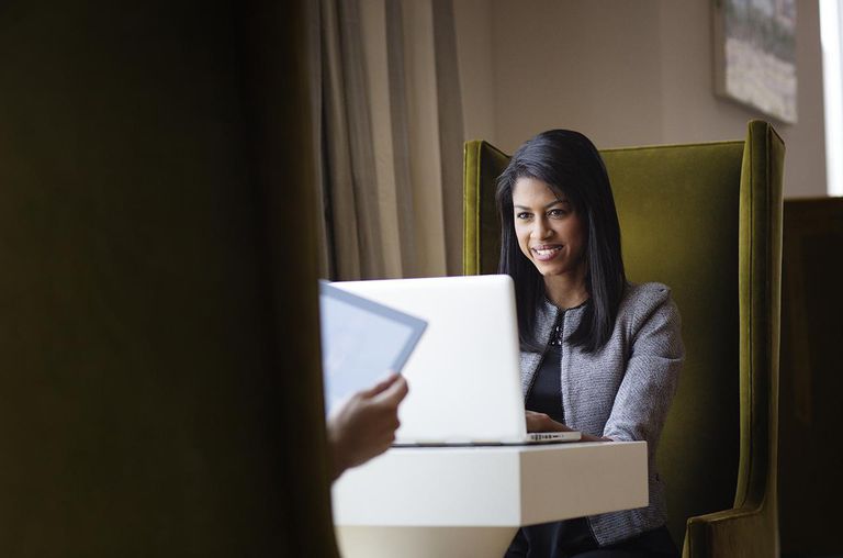 Woman Working on Laptop Opposite her Friend