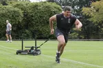 Rugby player running while pulling weighted sled