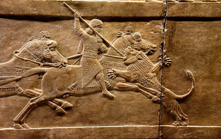 Assyrian king Ashurbanipal on his horse thrusting a spear onto a lion’s head