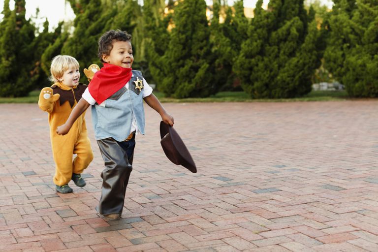 Two kids playing in Halloween costumes.