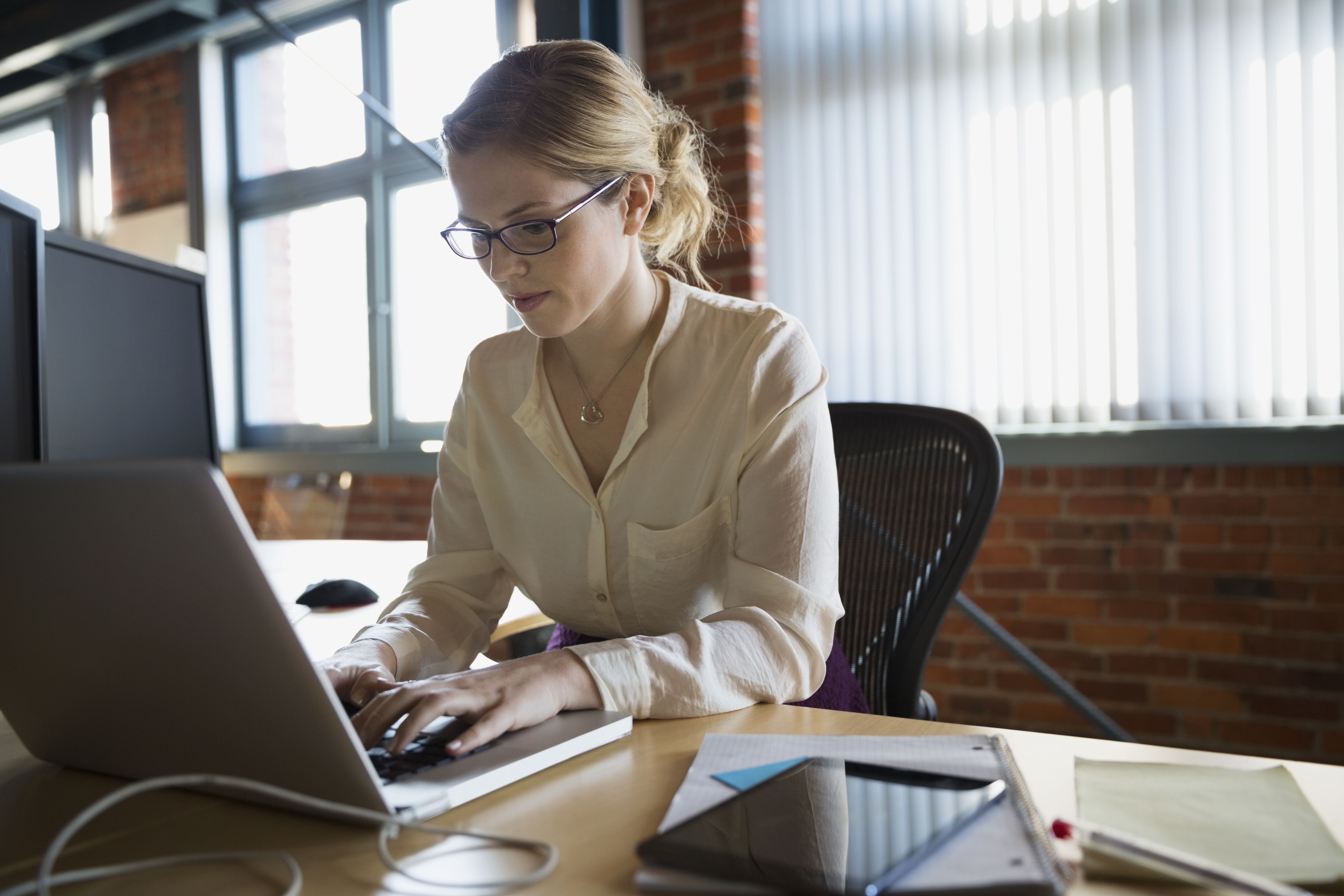 businesswoman working at laptop at office desk 595346467 58472af83df78c0230cfeeea