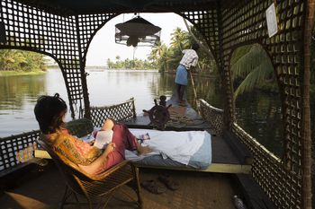 Tourist relaxes as she is punted through Keralan Backwaters near Alleppey.
