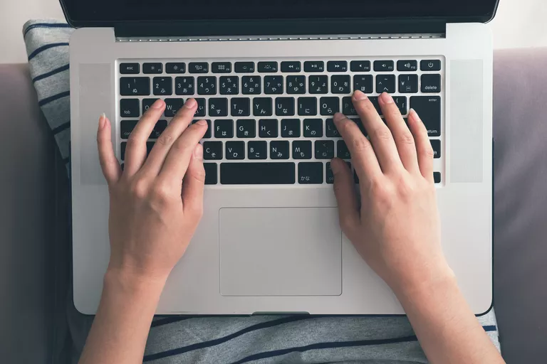 Hands resting on a computer keyboard.