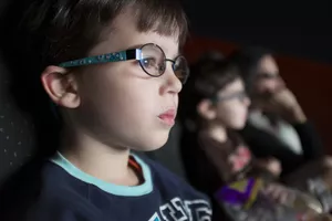 A boy watching a movie in a theater