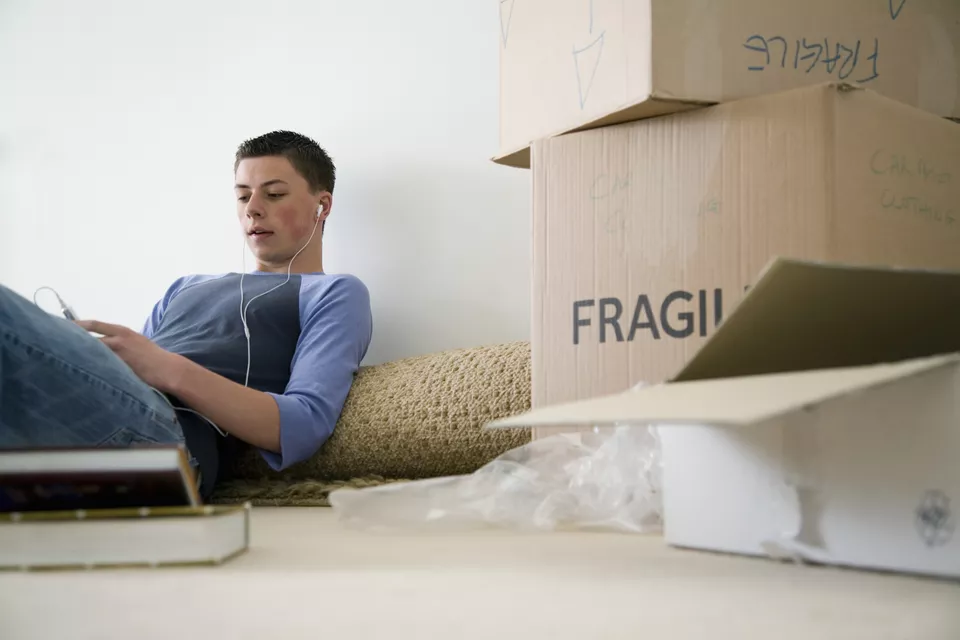 Teenager with unpacked boxes