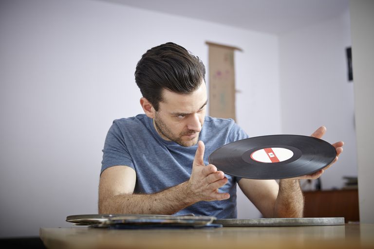 Man sitting at table with old vinyl records