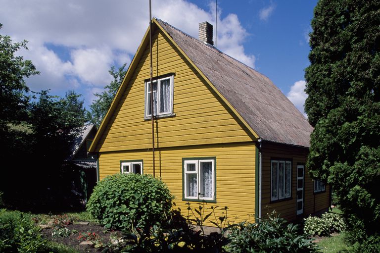 Mustard colored gable side of a house with steep roof