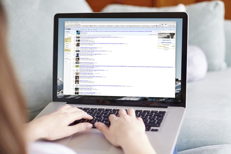 woman looking at Reddit on laptop