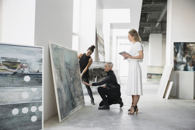Three people admiring painting