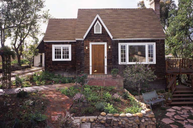 split-level roof, picture window, side chimney, portico with steep pediment, highly landscaped without grass