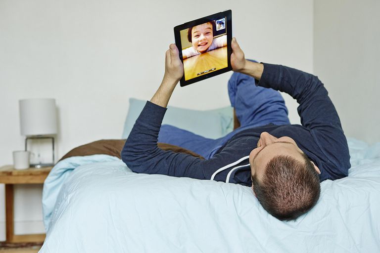 Lelaki menggunakan iPad untuk berbual video dengan budak lelaki