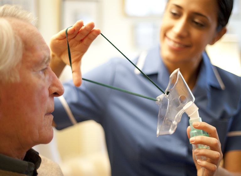 respiratory therapist placing mask on patient