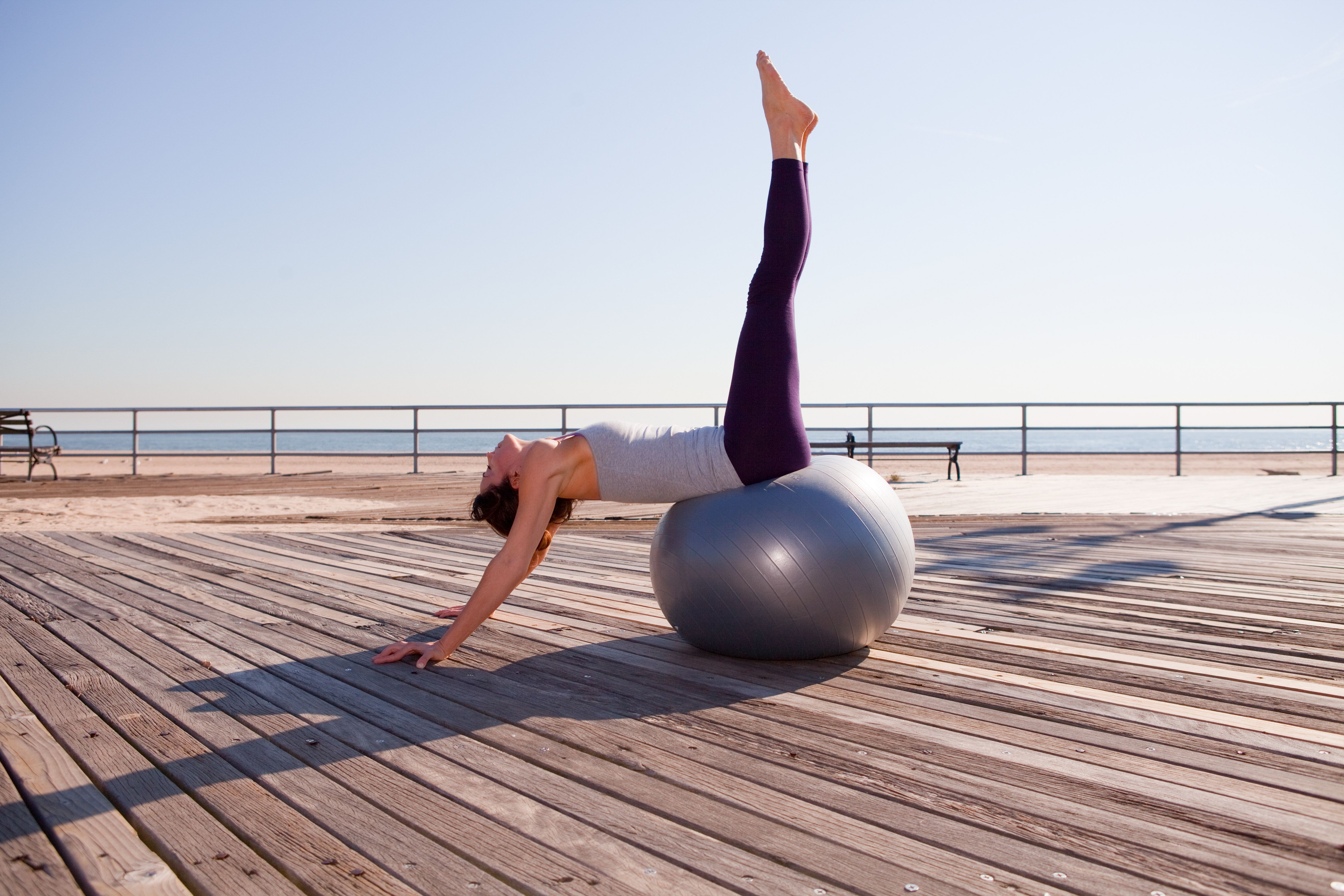 Woman Stretching On Exercise Ball On Promenade 141468057 59c961500d327a0011d02321 