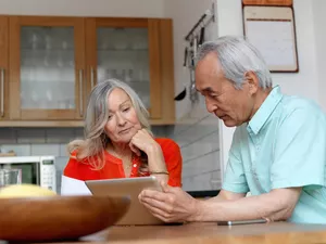 Older couple looking at tablet in kitchen