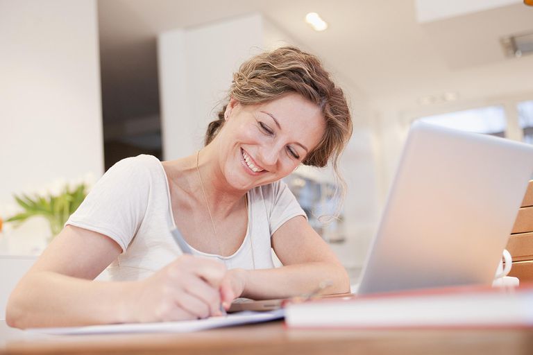 woman writing something down from computer screen