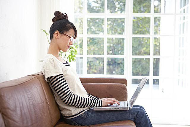 Young Asian woman typing on lap top computer