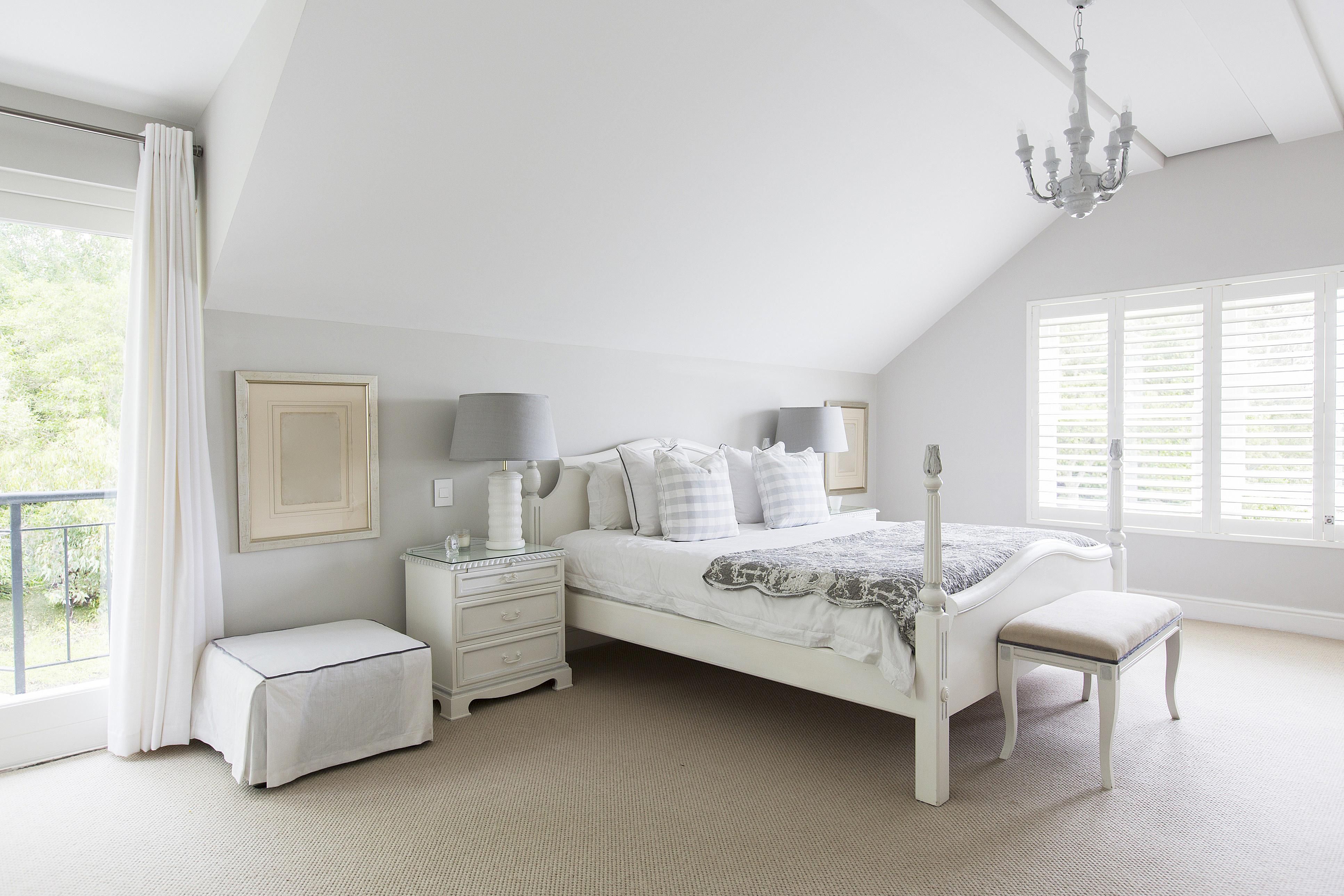 A White Bedroom With A Gallery Wall Of Black And White Photos