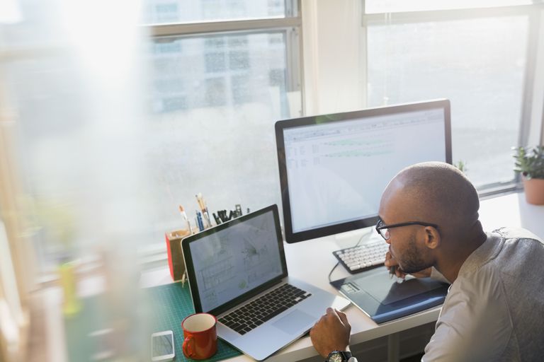 Designer using laptop at office desk