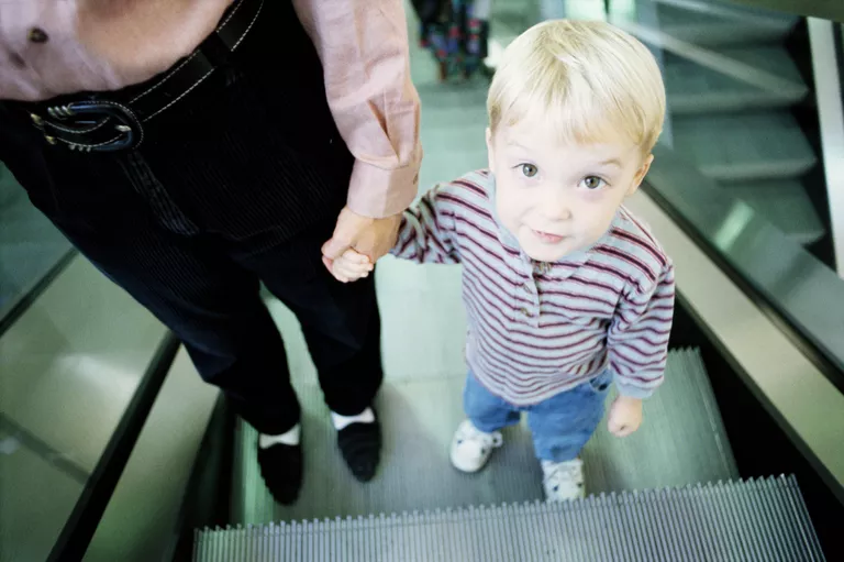 YOUNG BOY WITH MOTHER ON ESCALATOR