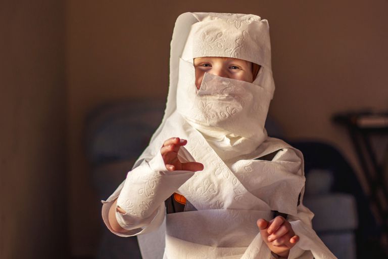 A child wrapped up as a mummy in toilet paper.