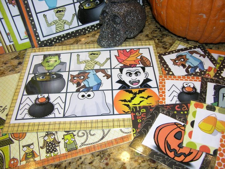 A table with Halloween bingo cards, a skull, and a pumpkin on it.