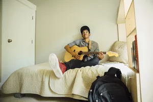 Kid practicing guitar in room