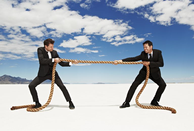 two businessmen playing tug-o-war with rope