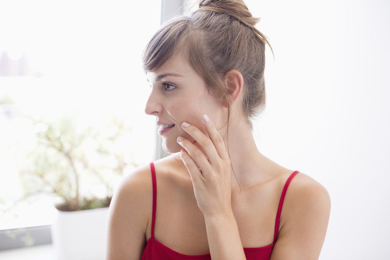 Woman applying beauty products to face