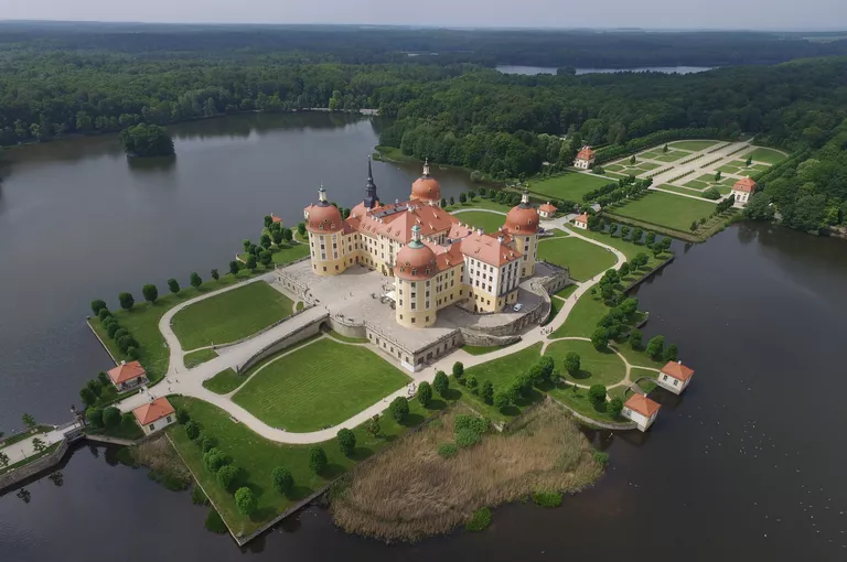 Overhead view of Moritzburg Castle, 4 red-domed turrets dominate the red hipped roof of this renovated hunting lodge nearly surrounded by water