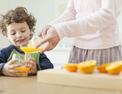 mother pouring orange juice for son 140873819 5ab1cc1bc064710036bf4f0b