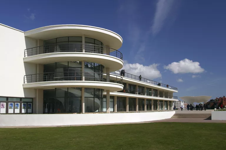 sleek white horizontal oriented building with central disc-shaped glassed balconies