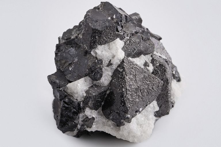 Darker rocks (containing a predominance of dark minerals) tend to be: