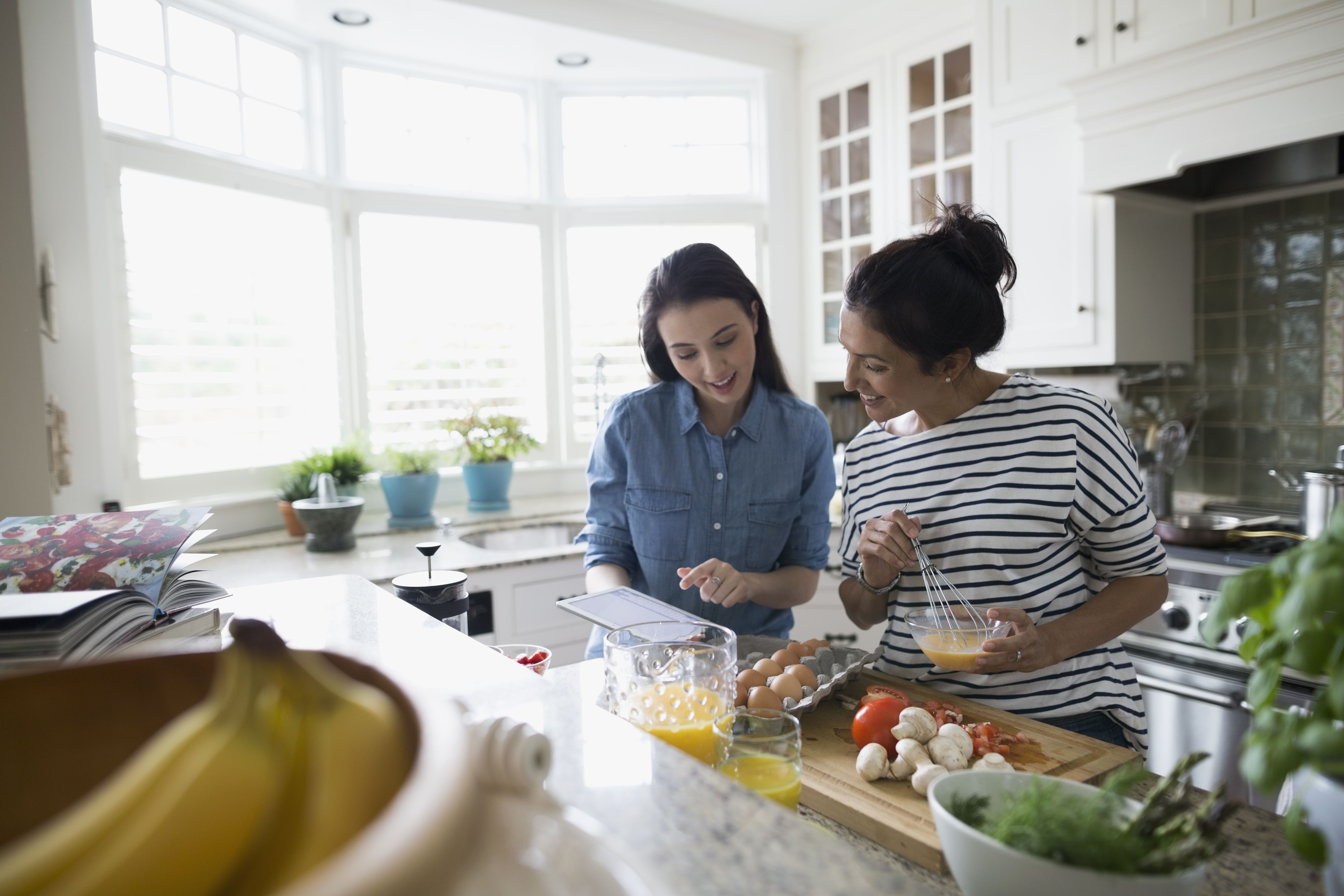 mother-and-daughter-cooking-with-recipe-in-kitchen-595347307-59dd5f72054ad900102dfac0.jpg