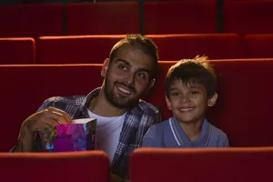 Father and son sitting in theatre