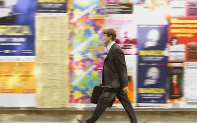 Man Walks by Advertisements