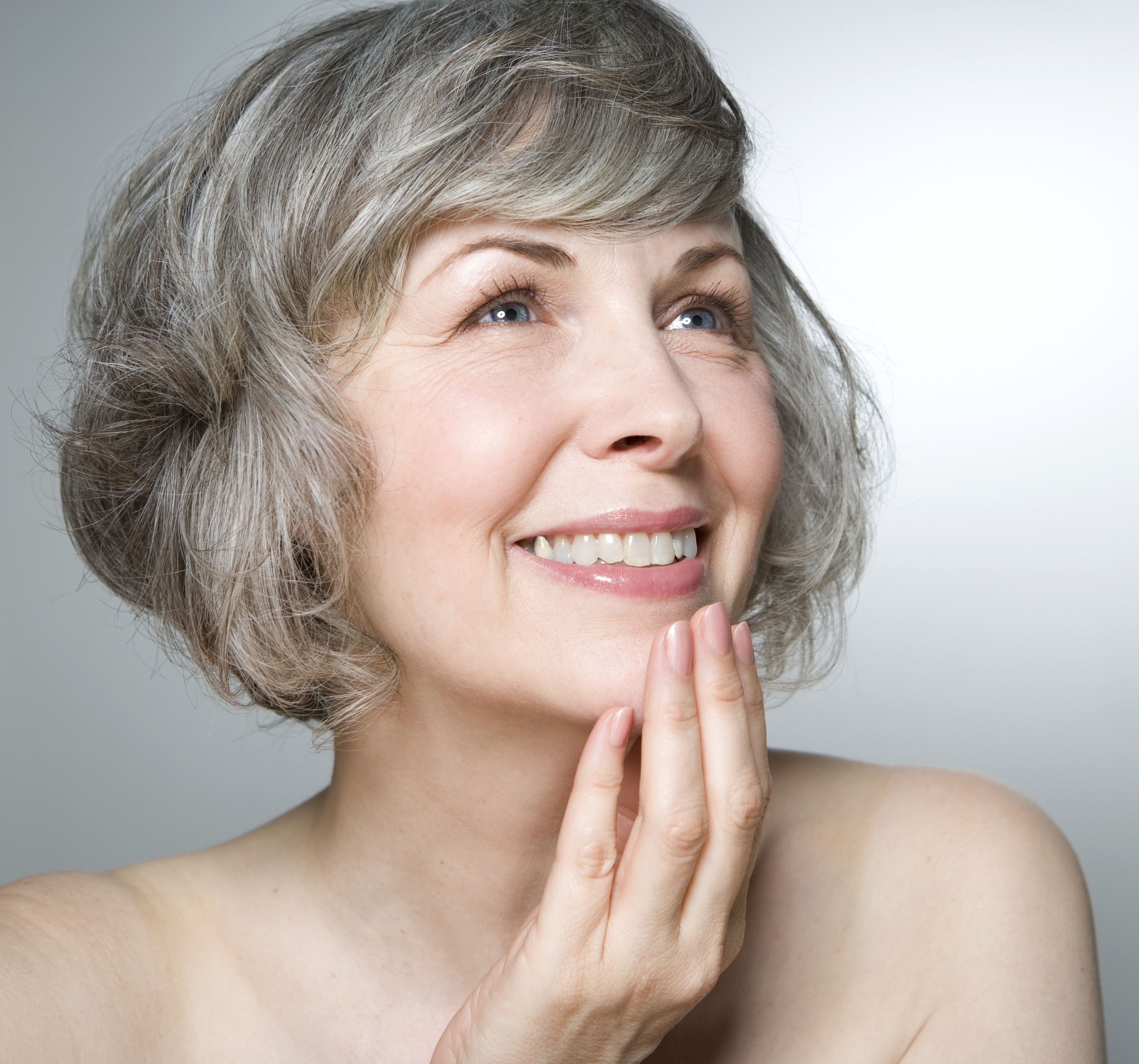 Overhead Head And Shoulder Portrait Of Beautiful Mature Woman Lying In Bed