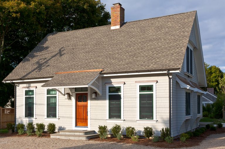 Center chimney Cape Cod Style home, 5-bay facade, no dormers, shed-like overhand over front door